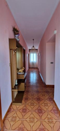 un corridoio vuoto con pareti rosa e pavimento piastrellato di B&B NINA a San Benedetto Val di Sambro