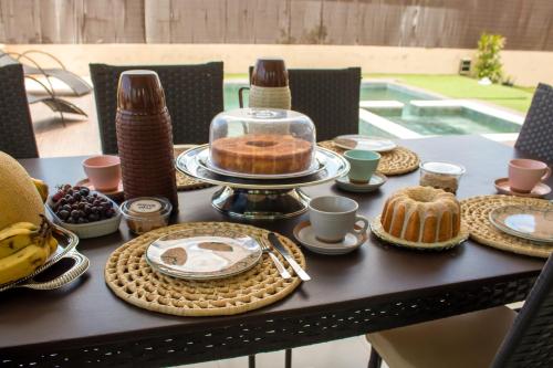 a table with cakes and other food on it at Espetacular Casa de Charme em São Miguel do Gostoso - Salou in São Miguel do Gostoso