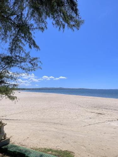 uma vista para uma praia arenosa com uma árvore em Nhà Nghỉ 86 Hàm Tiến em Phan Thiet