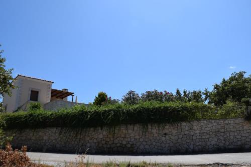a stone retaining wall with a house in the background at Aloe & Lotus Villas in Prinés