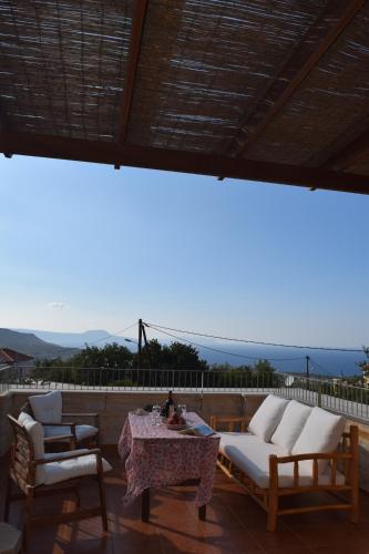 a patio with a table and chairs and a view of the ocean at Aloe & Lotus Villas in Prinés