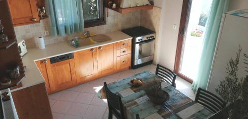 a kitchen with a table and a sink and a table and chairs at Cozy Apollon Villa, Sea View, Next To Galaxidi in Eratini
