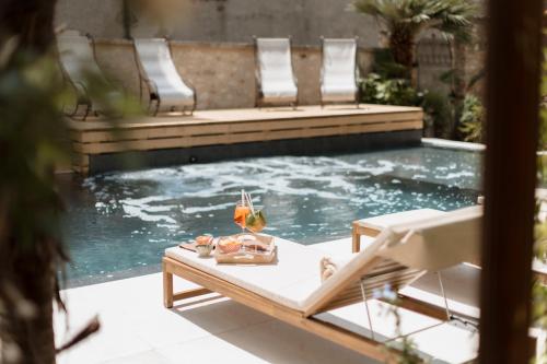 a pool with chairs and a table with a glass of wine at Classique in Lazise