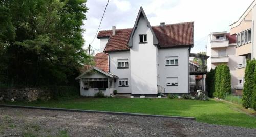 una casa blanca con un patio y un edificio en Kuća JEKA, en Vrnjačka Banja