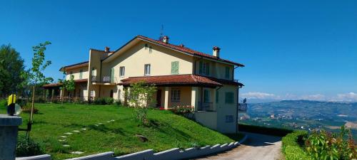 a house on top of a grassy hill at Villa Bellavista Alba, B&B in Alba