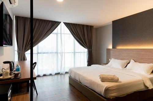 a bedroom with a large bed and a large window at RM Hotel in Muar