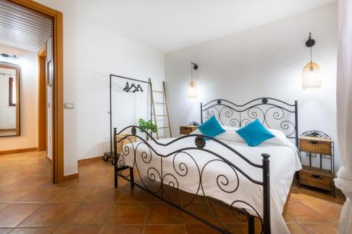 Un dormitorio con una cama grande con almohadas azules. en Aetòs Home, Porto Pino hill, en Porto Pino