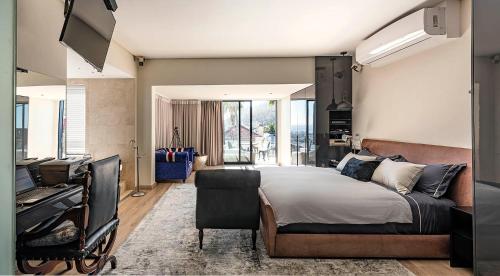 a bedroom with a bed and a desk and a television at Villa Legacy in Cape Town