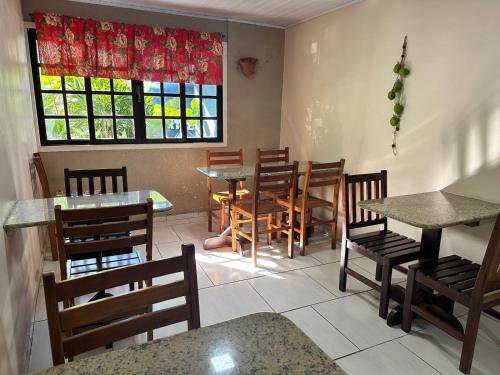 ein Restaurant mit Tischen und Stühlen und einem Fenster in der Unterkunft Hotel D'Luz in Itapema