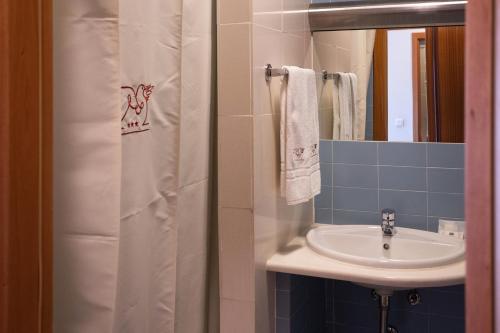 a bathroom with a sink and a shower curtain at Hotel Pombalense in Pombal
