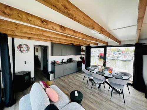 a kitchen and a living room with a table and chairs at Surla Houseboat "De Albatros" in Monnickendam Tender included in Monnickendam