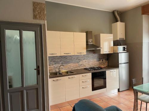 a kitchen with white cabinets and a stove top oven at Grazioso Trilocale Centro/Stazione in Brescia