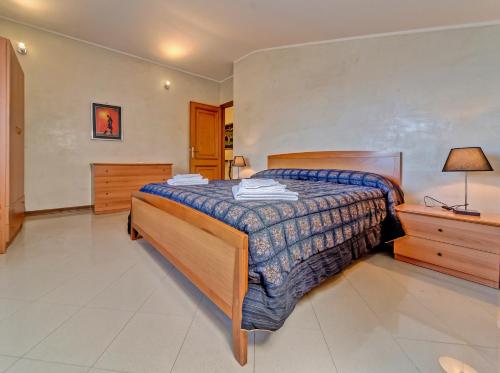 a bedroom with a bed and a dresser and lamp at Villa Magnolia in Bolsena