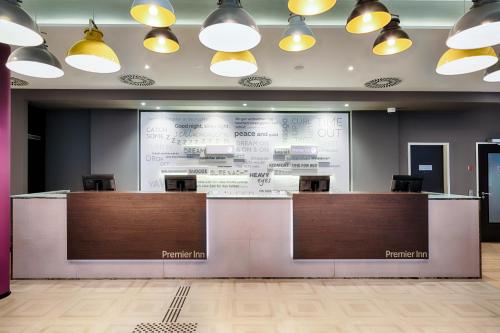 a lobby with a reception desk and a large screen at Premier Inn Düsseldorf City Friedrichstadt in Düsseldorf