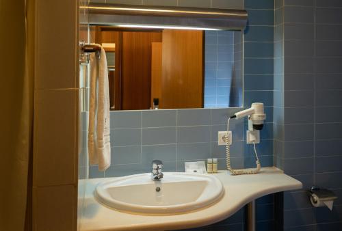 a bathroom with a sink and a mirror at Hotel Pombalense in Pombal