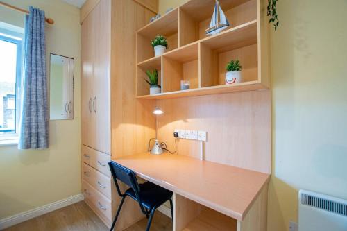 a home office with a desk and shelves at 83 - Superb Townhouse by Shortstays in Galway