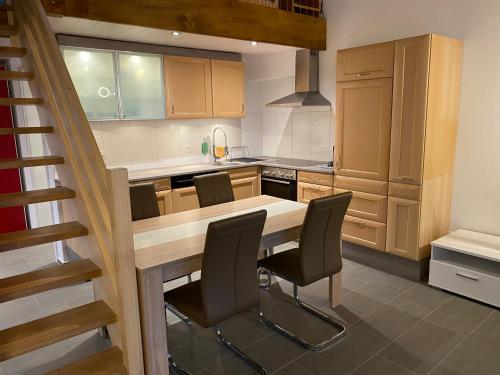 eine Küche mit einem Holztisch und Stühlen in der Unterkunft Bienvenue chez les Quadeurs 