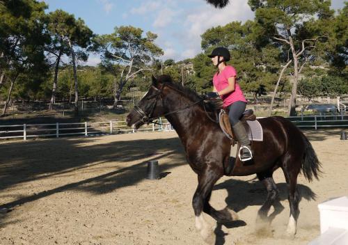 a woman riding a horse in an arena at Fantastic Junior Villa CZ02 Salamis with Gorgeous Views, Aphrodite Hills in Kouklia