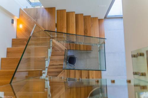 - un escalier en verre dans une chambre dotée de parquet dans l'établissement Carpe Diem Villa - Luxurious, 15km From The Beach, à Vederoi