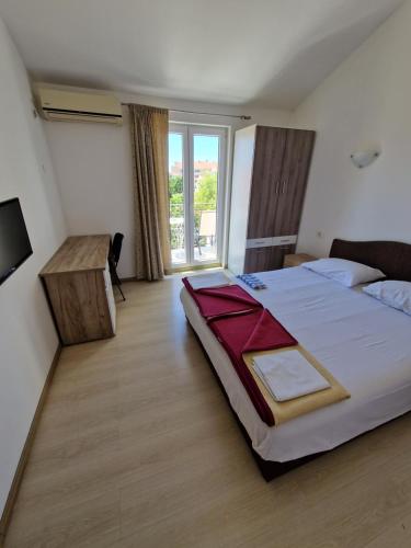 ein Schlafzimmer mit einem großen Bett und einem großen Fenster in der Unterkunft Guest House Damjana in Budva