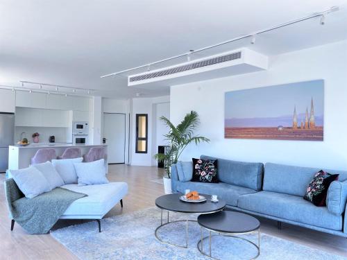 特拉維夫的住宿－TEL AVIV - Sea front Penthouse - 1604，客厅配有蓝色的沙发和桌子