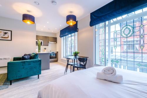 a bedroom with a large bed and a kitchen at Stylish, Central and Spacious Apartments in Southport in Southport