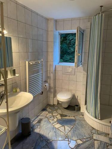 La salle de bains est pourvue d'un lavabo, de toilettes et d'une fenêtre. dans l'établissement Urlaub im Naturschutzgebiet, à Detmold