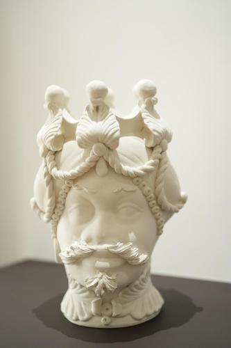 a white vase with four people on top of it at Enea Suite in Trapani