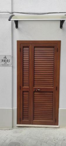 una porta di legno sul lato di un edificio di ARAS b&b - a Mazzarino