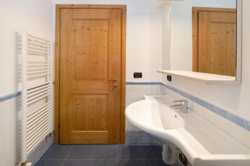 baño con lavabo y puerta de madera en Baita Valandrea 3, en Livigno