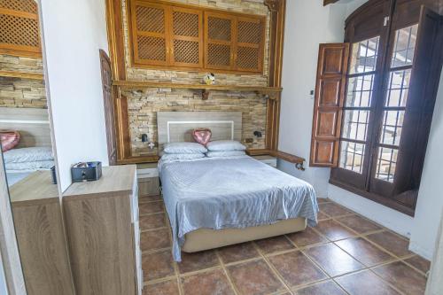 a bedroom with a bed and a brick wall at Villa Los Leones Nerja in Nerja