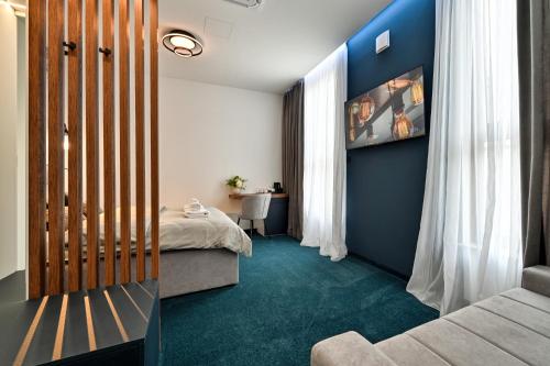 a bedroom with a bed and a room with blue walls at Rooms Florek & Florica in Križevci