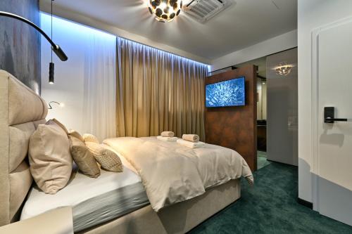 a bedroom with a bed and a tv on a wall at Rooms Florek & Florica in Križevci