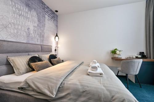 a bedroom with a large bed with towels on it at Rooms Florek & Florica in Križevci