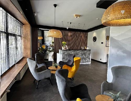 a living room with chairs and a table with yellow legs at WRZOS resort & wellness **** DOMKI CAŁOROCZNE in Węgierska Górka