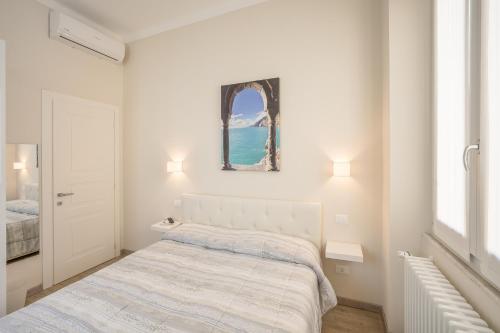 ein weißes Schlafzimmer mit einem Bett und einem Fenster in der Unterkunft Maspes house in Santa Margherita Ligure