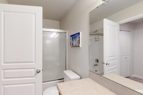 a white bathroom with a shower and a toilet at Seventh Mountain Studio in Bend