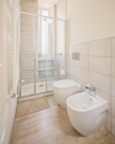 a white bathroom with a toilet and a sink at Maspes house in Santa Margherita Ligure