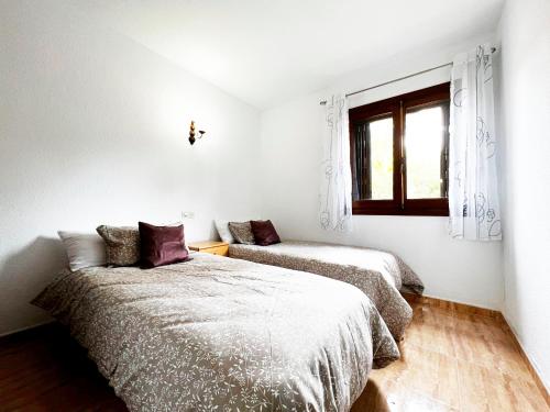 2 Betten in einem weißen Zimmer mit Fenster in der Unterkunft Book It Casona Apartment Moraira in Moraira