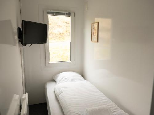 um quarto branco com uma janela e uma televisão em Cozy Container Rental - 3BR - 20 min to capital em Strendur