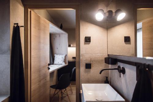 uma casa de banho com um lavatório e um espelho em Rousa little guesthouse Cosy em Rasun Anterselva