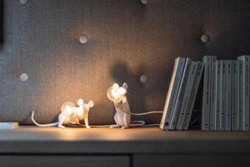 two toy cats sitting on a shelf next to books at Rousa little guesthouse Kombi in Rasun di Sopra