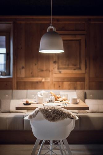 a kitchen with a table with a chair and a light at Rousa little guesthouse Kombi in Rasun di Sopra