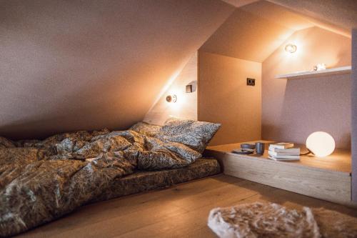 a bedroom with a bed and a table with a lamp at Rousa little guesthouse Cosy Up in Rasun di Sopra