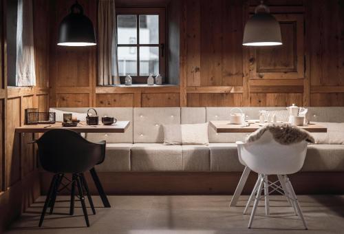 a living room with a couch and two chairs at Rousa little guesthouse Cosy Plus in Rasun di Sopra