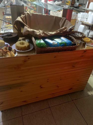 a counter with a table with plates of food at SALATA Hotel CENTRO in Jardinópolis