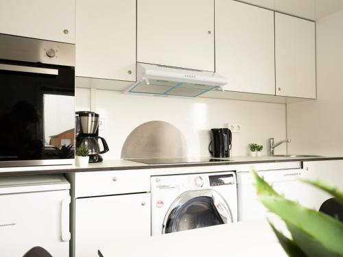 a white kitchen with a washing machine in it at Container Rental - 3BR in Strendur