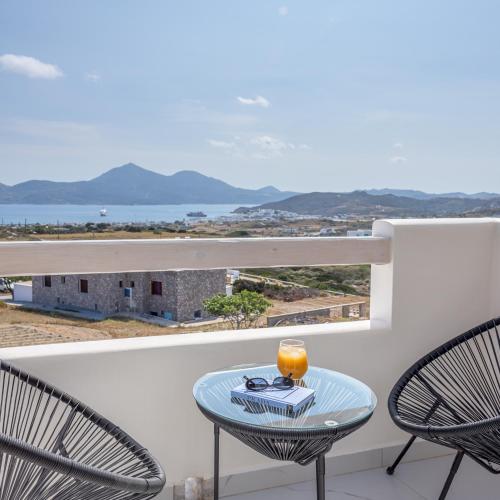 a table and chairs on a balcony with a view at Thea Sunset Suites in Mytakas