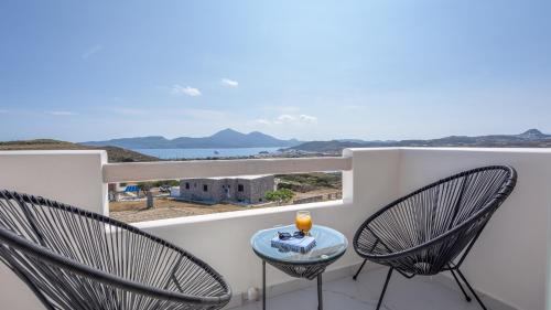 a balcony with two chairs and a table with a view at Thea Sunset Suites in Mytakas