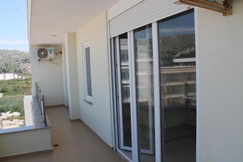 a balcony with sliding glass doors in a building at Blue Apartments & Hotel Shengjin in Shëngjin
